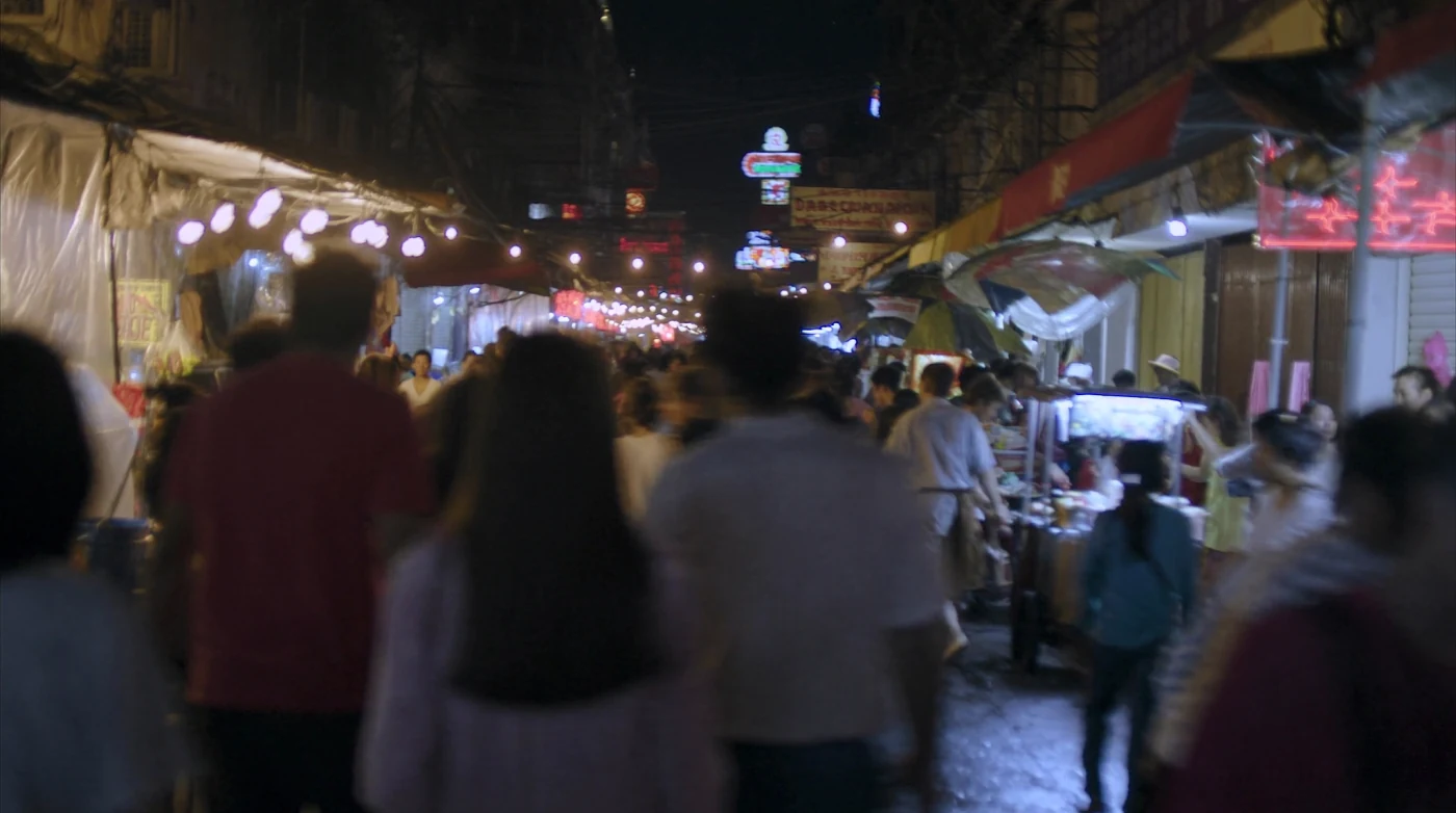 Neon signs above the crowd on Yaowarat Road in Bangkok at night