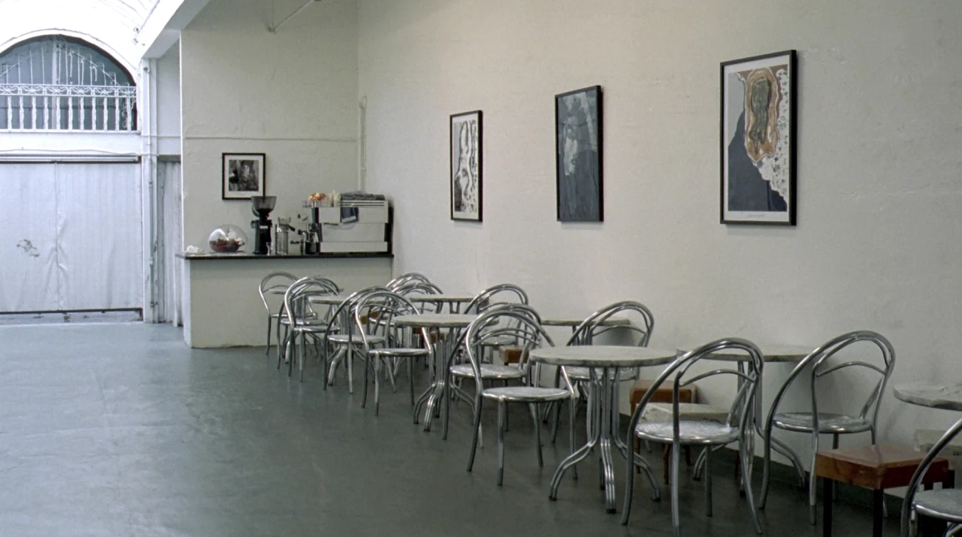 Gallery cafe in Bangkok with artwork on white walls and a small coffee bar