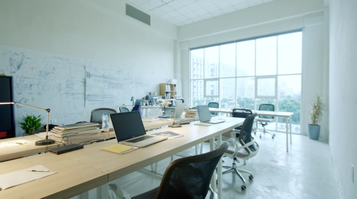 Open plan coworking floor in Bangkok with desks, monitors and daylight from tall windows
