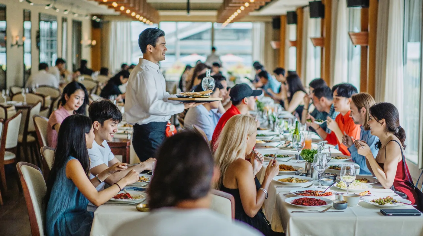 Busy Indian restaurant dining room in Bangkok with full tables at lunch service