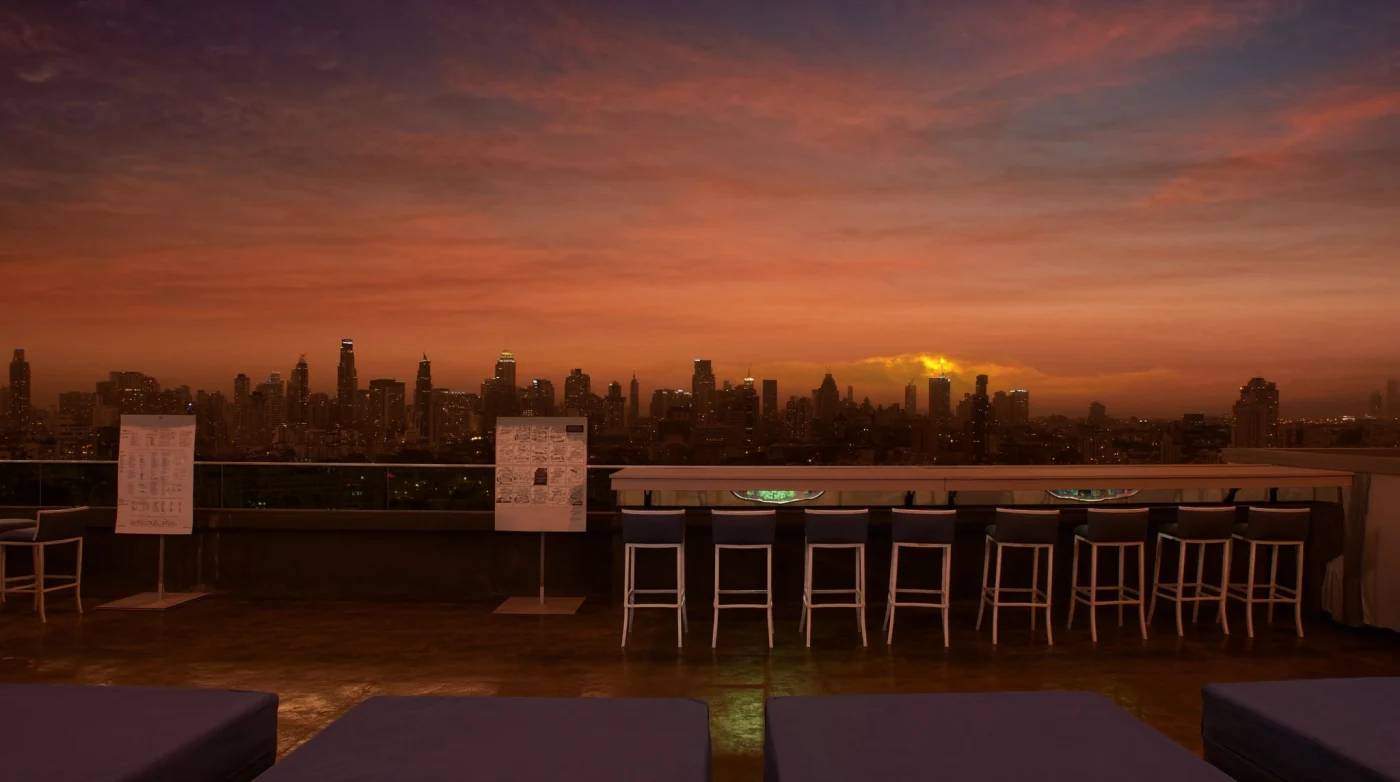 Open rooftop bar deck facing the Bangkok skyline at sunset