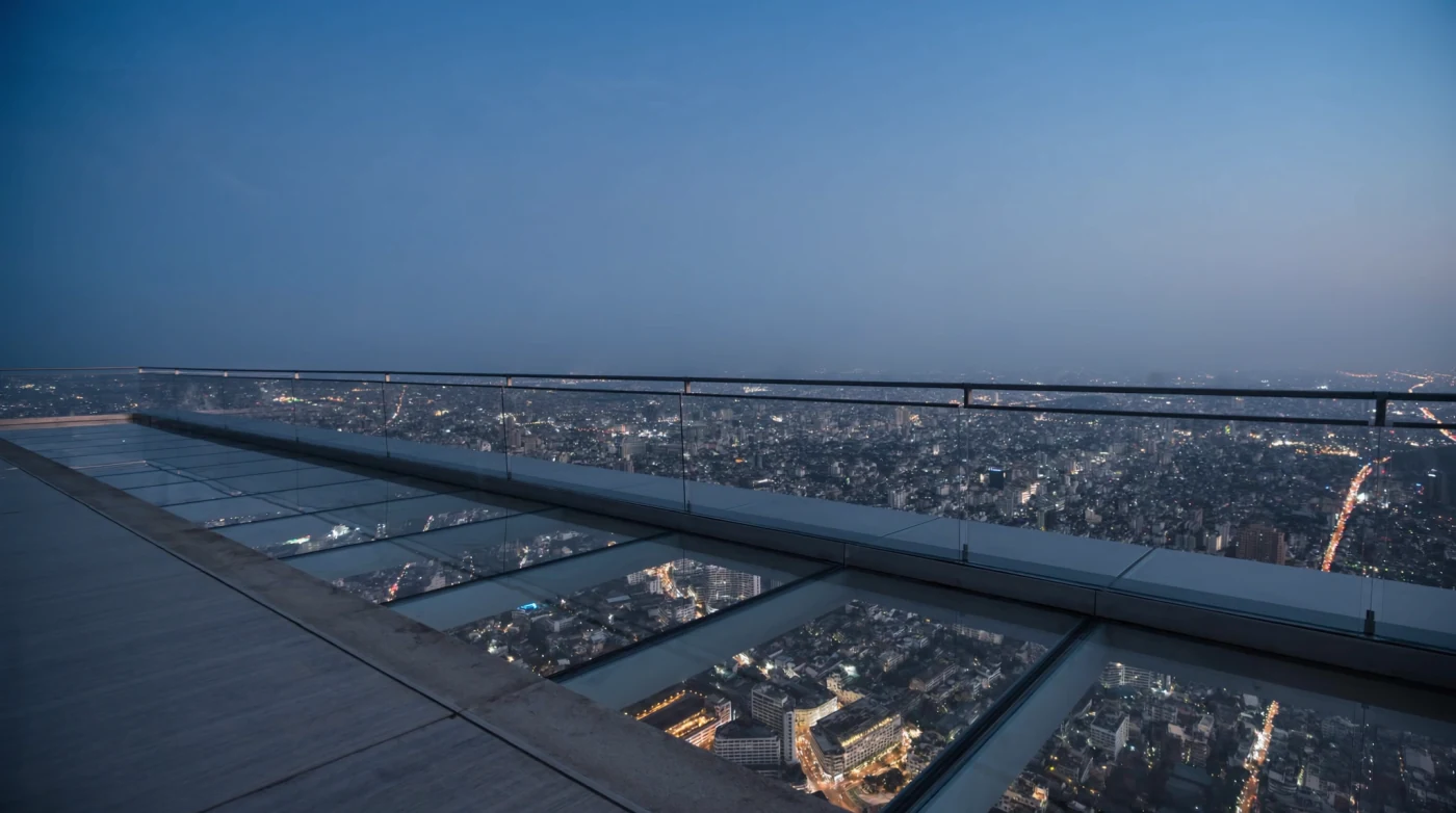 Glass-floored rooftop skywalk above the Bangkok city grid at dusk