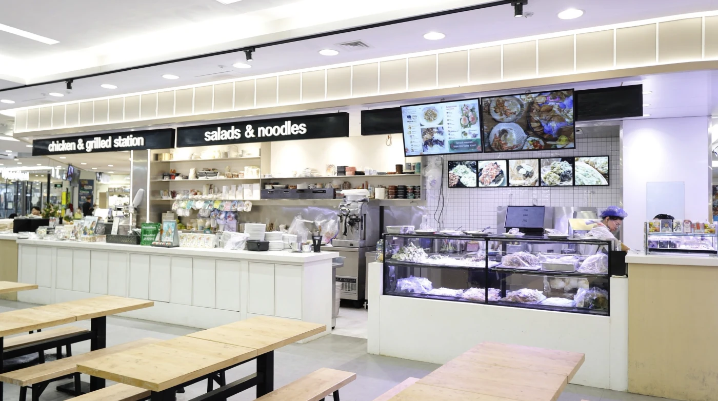 Open food counters and clean shared tables in a Bangkok mall food hall