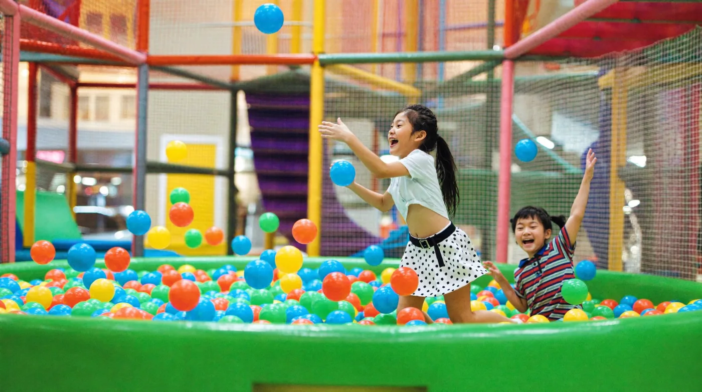 Children jumping into the ball pit of an indoor play zone in a Bangkok mall