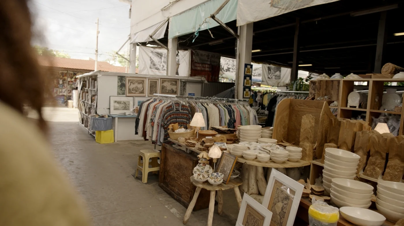 Ceramics and woodwork stall in a shaded aisle at Chatuchak Weekend Market