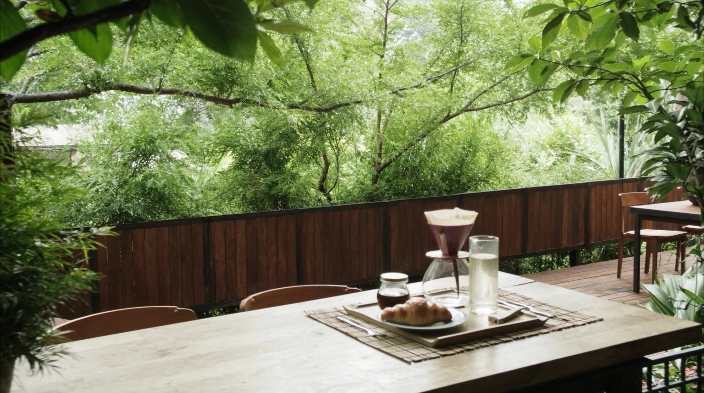 Outdoor table under trees at a garden coffee roastery in Ari, Bangkok