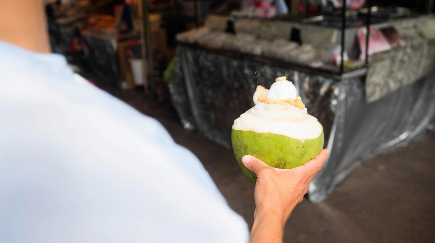 Coconut ice cream served in a young coconut shell at a Bangkok market