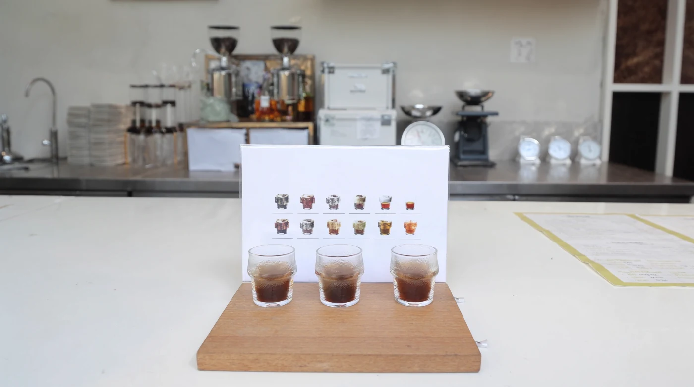 Filter coffee tasting flight of three glasses on a board in a Bangkok cafe