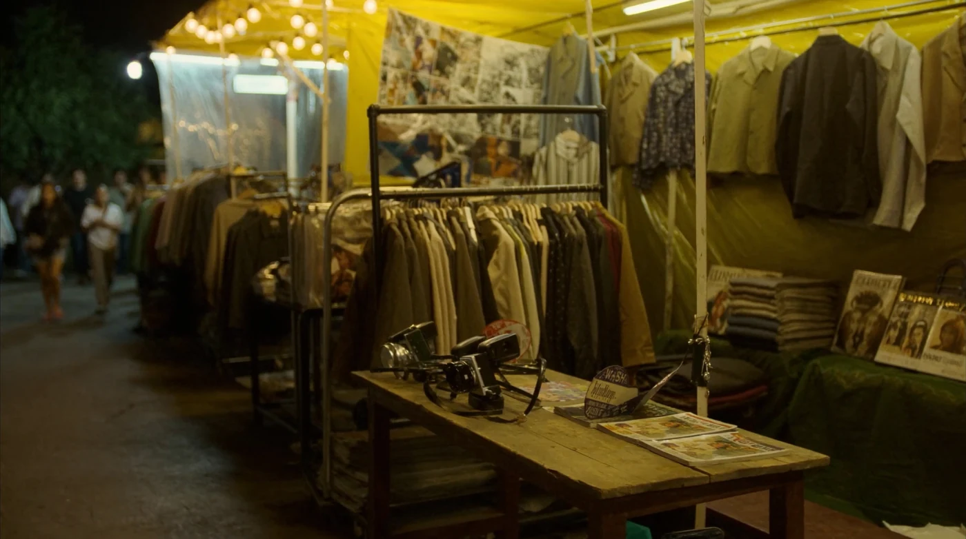Vintage clothing and second hand goods laid out on tables at a Bangkok night market