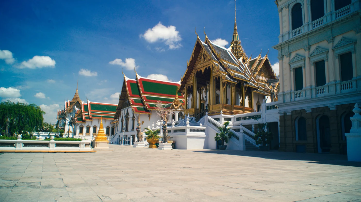 Paved courtyard with mosaic covered towers inside the Grand Palace in Bangkok