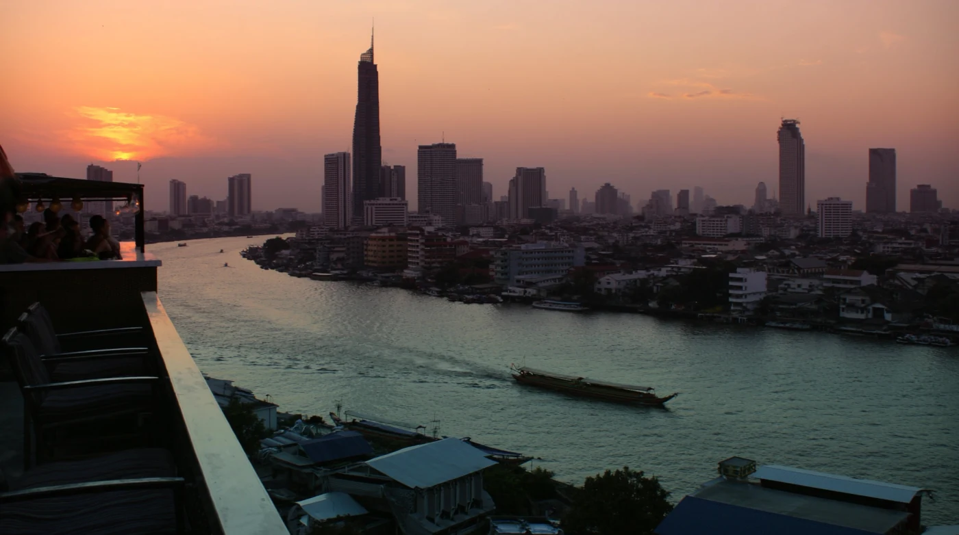 View over the Chao Phraya River from a Bangkok rooftop terrace at dusk