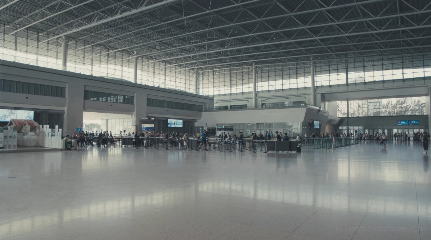 Wide arrivals hall of a modern airport with a high glass roof